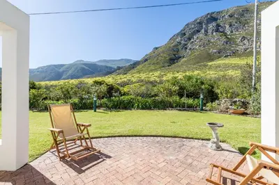 a patio with chairs and a view of a mountain at 42 on 4th in Hermanus