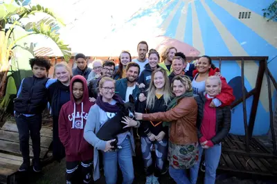 a group of people posing for a picture at Saltycrax Backpackers and Surf Hostel in Bloubergstrand