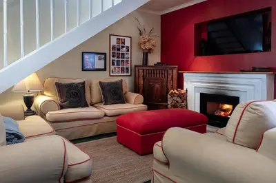 a living room with couches and a fire place at Cook's Cottage in Franschhoek