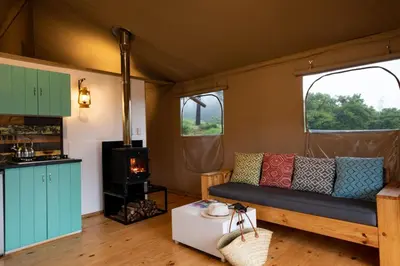 a living room with a couch and a stove at AfriCamps at Doolhof Wine Estate in Wellington