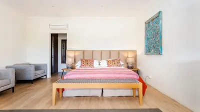 a bedroom with a king sized bed and a couch at Lady Loch Country House in Wellington