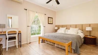 a bedroom with a bed and a desk and a window at Lady Loch Country House in Wellington