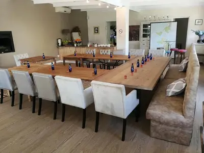 a large wooden table with white chairs around it at Lady Loch Country House in Wellington