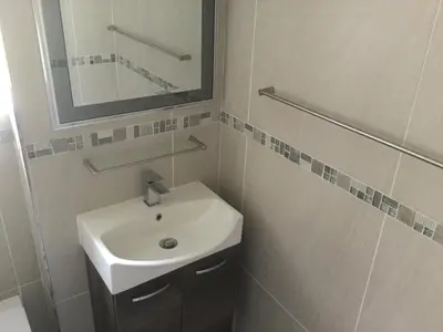 a bathroom with a sink and a mirror at Greenways Strand Golf Beach C3 in Strand