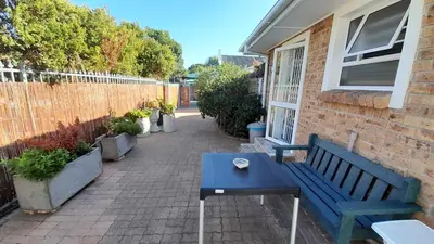 a blue bench sitting next to a brick building at Vergenoegd Guesthouse in Panorama