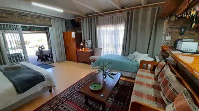 a bedroom with a bed and a living room at Vergenoegd Guesthouse in Panorama