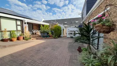 a courtyard of a house with potted plants at Vergenoegd Guesthouse in Panorama