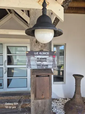 a lamp hanging from a pole with a sign on it at HERMANUS , SANDBAAI holiday house in Hermanus
