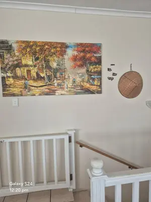 a painting hanging on a wall next to a crib at HERMANUS , SANDBAAI holiday house in Hermanus