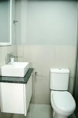 a white bathroom with a sink and a toilet at Cape Town Micro Apartments in Cape Town
