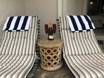 two chairs and a bottle of wine on a table at Hemel en Aarde cottages in Hermanus