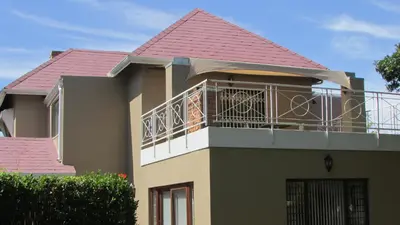 a house with a balcony with a red roof at Pinewoods Rest in Somerset West
