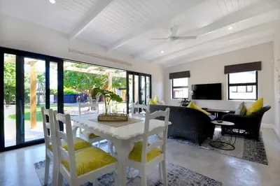 a dining room with a white table and chairs at SAFFRON COTTAGE in Hermanus
