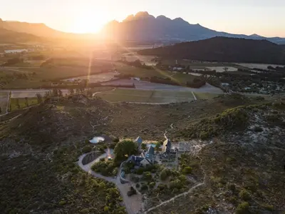 an aerial view of a house on a hill with the sunset at 7 Koppies in Franschhoek