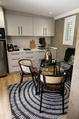 a kitchen with a table and chairs in a room at Cape Village Lodge in Durbanville