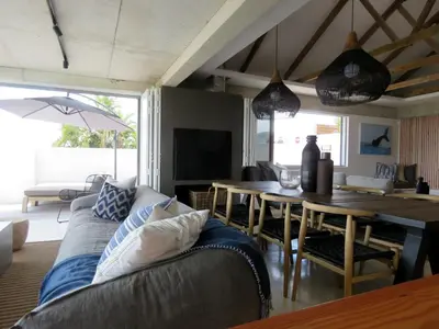 a living room with a couch and a table at Troon Beach Cottage Hermanus in Hermanus