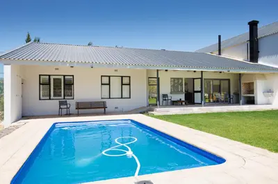 a house with a swimming pool in front of it at De Hoop Farm - Mountain View in Breerivier