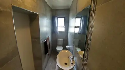 a bathroom with a sink and a toilet and a mirror at Blouberg Beach Retreat in Bloubergstrand