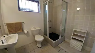 a bathroom with a shower and a toilet and a sink at Blouberg Beach Retreat in Bloubergstrand
