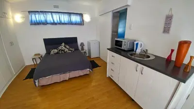 a bedroom with a bed and a sink in it at Blouberg Beach Retreat in Bloubergstrand