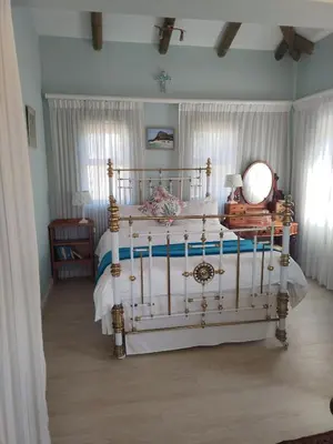a bedroom with a bed with a white bed frame at Gogo's garden apartment in Pringle Bay