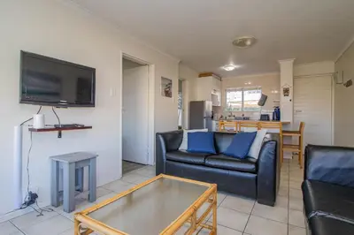 a living room with a couch and a table at 176 hbc in Hermanus