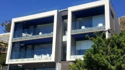 a large building with glass windows on it at GORDON's SHORE LUXURY APARTMENTS - Solar Powered in Gordonʼs Bay