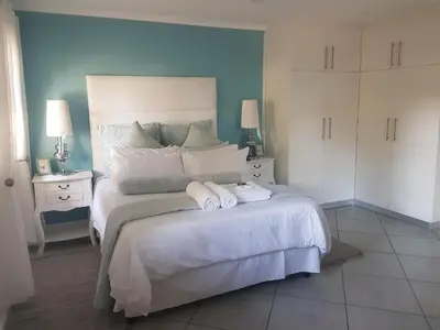 a bedroom with a large bed with two towels on it at Alyssa's Inn Boutique Guesthouse in Cape Town