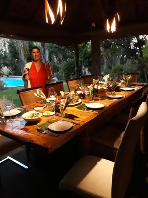 a woman standing in front of a long wooden table at Khashamongo B & B in Somerset West