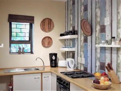 a kitchen with a sink and a stove top oven at Khashamongo B & B in Somerset West