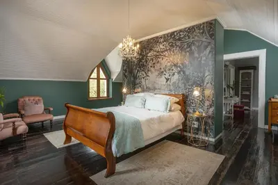 a bedroom with a bed and a painting on the wall at Caledon Grace Guesthouse in Caledon