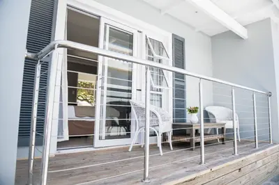 a balcony with a table and chairs on a porch at The Whale on Main B&B in Hermanus