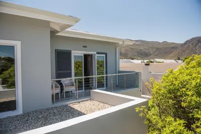 a house with a balcony with a view of the mountains at The Whale on Main B&B in Hermanus