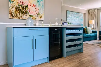 a kitchen with a blue island in a living room at Hermanus Family Getaway - Near The Beach in Hermanus