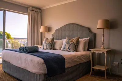 a bedroom with a large bed with a large window at Hermanus Family Getaway - Near The Beach in Hermanus