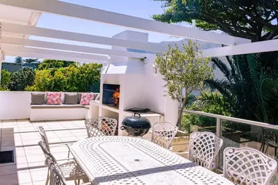 a patio with a table and chairs and a fireplace at Hermanus Family Getaway - Near The Beach in Hermanus
