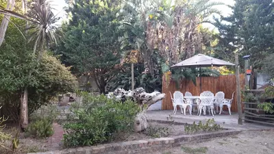 a patio with a table and chairs and an umbrella at Oak on Blair in Somerset West