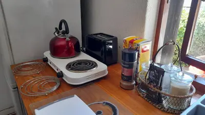 a counter with a microwave and a toaster and a tea kettle at Oak on Blair in Somerset West