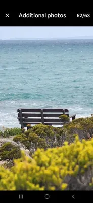 a wooden bench sitting on top of a beach at Nerf-af ROOMS at Onrus , Hermanus in Hermanus