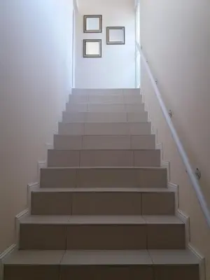 a staircase with three pictures on the wall at Flamingo Palms in Table View