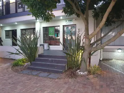 a building with stairs and a tree in front at Tyger Hills Guest House in Bellville