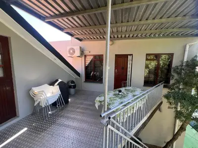 a balcony of a house with a table and chairs at 3 on Nebraska Accommodation in Bellville