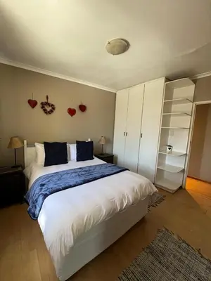 a bedroom with a large white bed with blue pillows at 3 on Nebraska Accommodation in Bellville