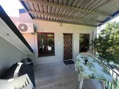 a balcony of a house with a table and a staircase at 3 on Nebraska Accommodation in Bellville