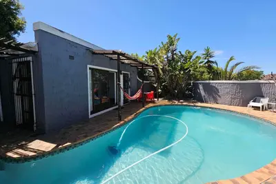 a swimming pool next to a house at Panorama Indlu in Cape Town