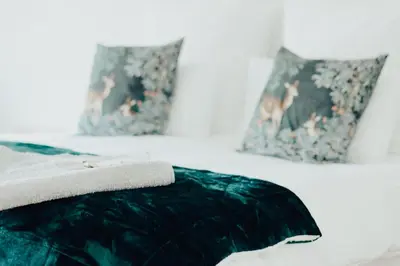 a bed with a green blanket and pillows on it at Becketts Bliss in Worcester