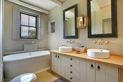 a bathroom with two sinks and a bath tub and a tubermottermott at Villa Simondium in Franschhoek