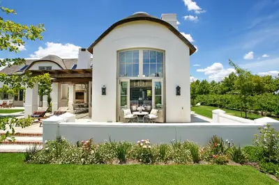 a house with a white fence in front of a yard at Villa Simondium in Franschhoek