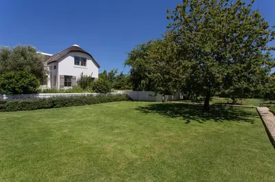 a large yard with a tree in front of a house at Villa Simondium in Franschhoek