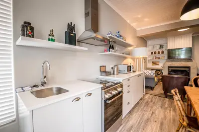 a kitchen with a sink and a stove top oven at The Corner House L'A-nnexe in Franschhoek